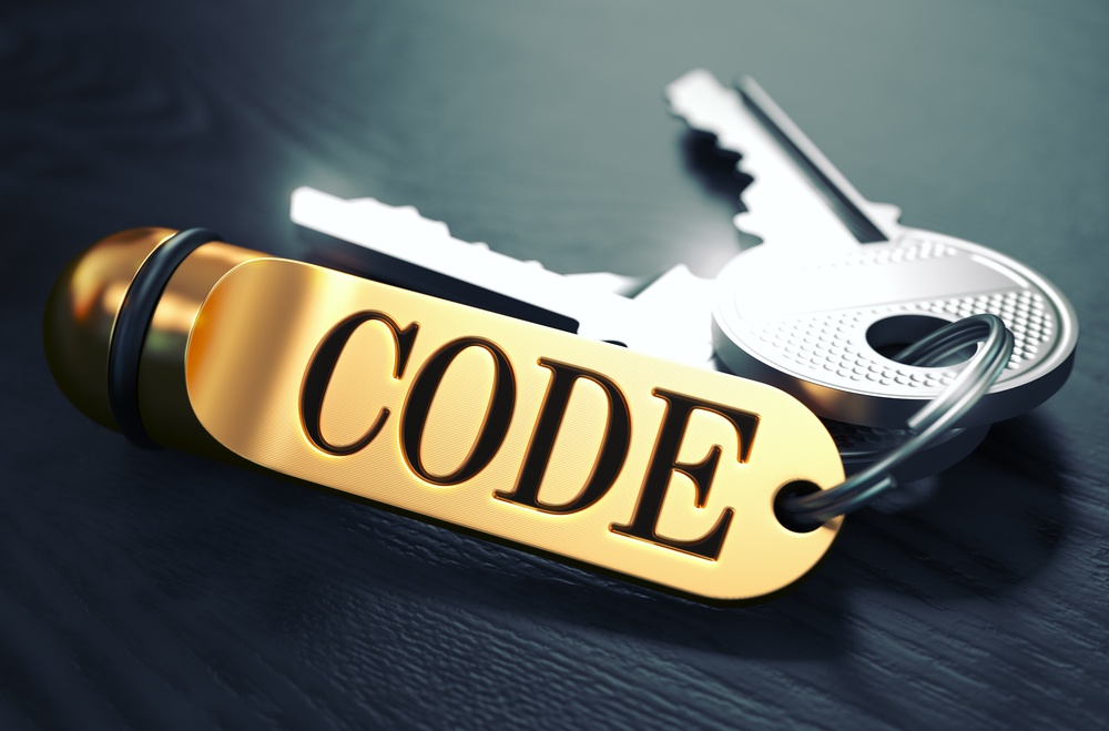 Keys and Golden Keyring with the Word Code over Black Wooden Table with Blur Effect. Toned Image..jpeg